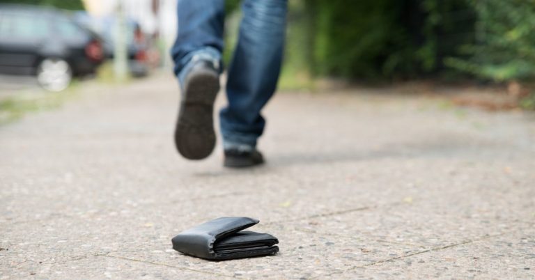 7 Ways You're Losing Money_Picture of wallet on ground with man walking away