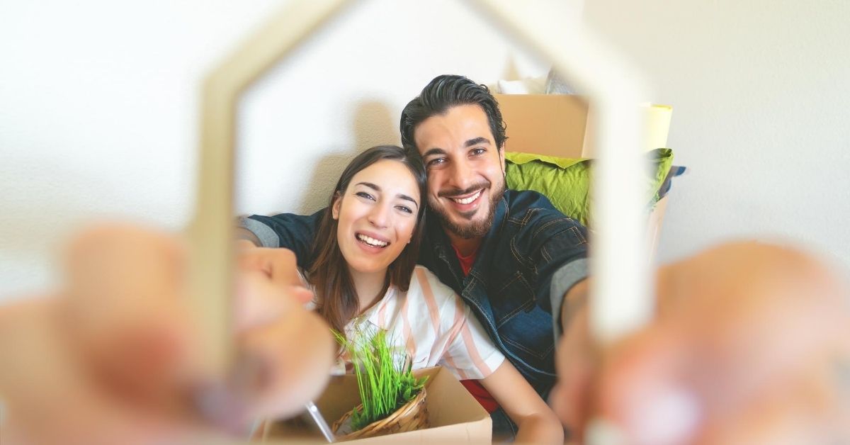 Best Budgeting Apps - picture of couple seen through frame of a house they are holding up