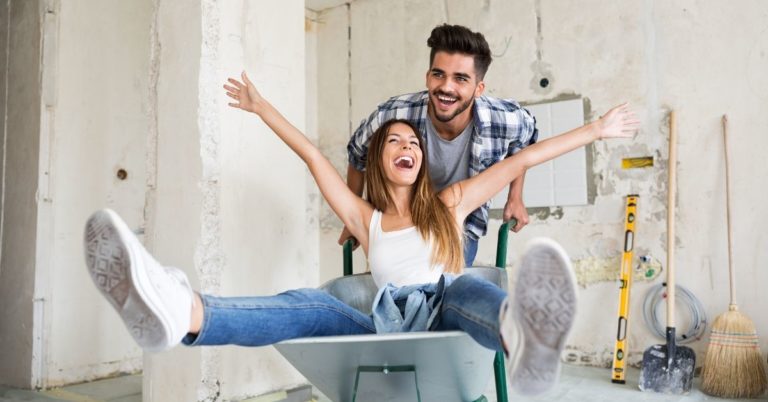 Best Personal Loans - picture of man pushing woman in wheelbarrow in empty house