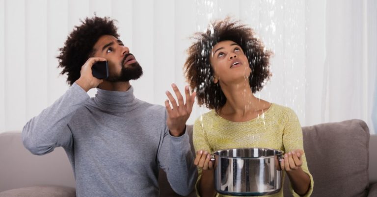 Best Ways to Use Personal Loan - Picture of a couple on couch with bucket and water spilling from ceiling