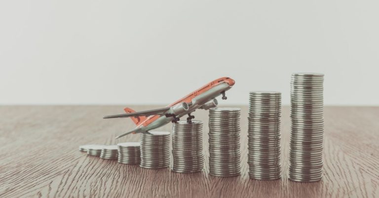 CIT Bank Money Market Review - picture of toy plane sitting on increasing stack of coins