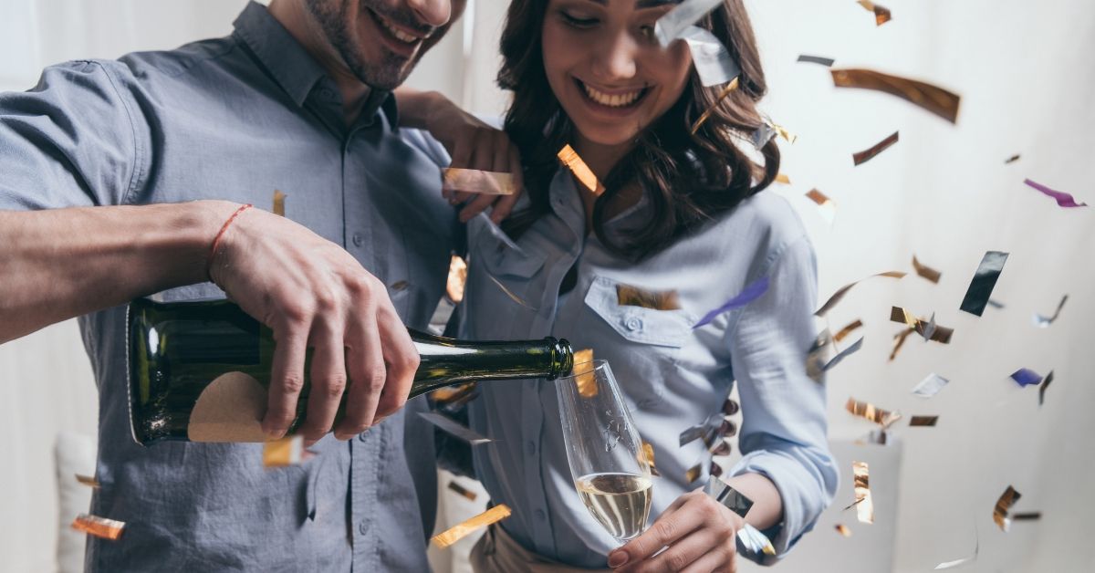 Combining incomes to pay off debt - picture of couple celebrating with champagne