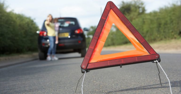 What is an Emergency Fund - picture of hazard flag in road with broken down car in background