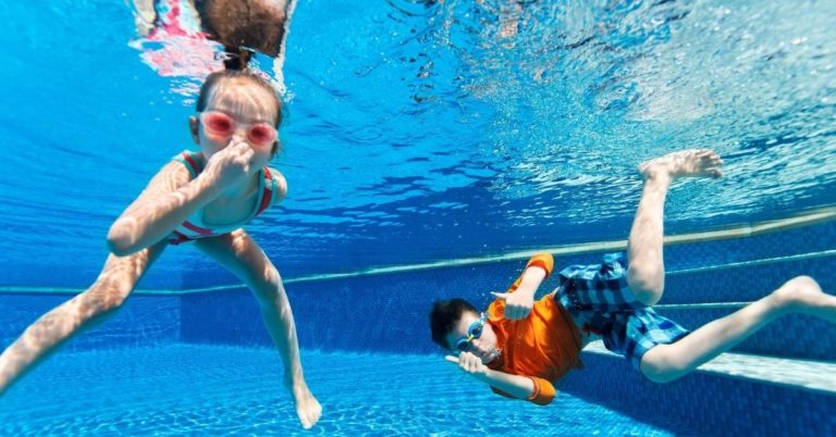 Fun Ways We're Saving Money This Summer - picture of kids swimming in pool underwater