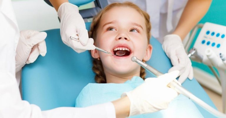 How to Combat the Crazy Cost of Dental Care - picture of little girl in dentist chair