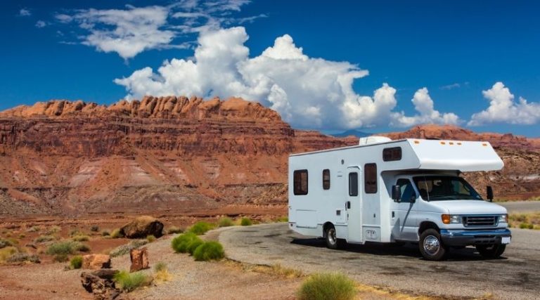 image of RV on road with desert landscape