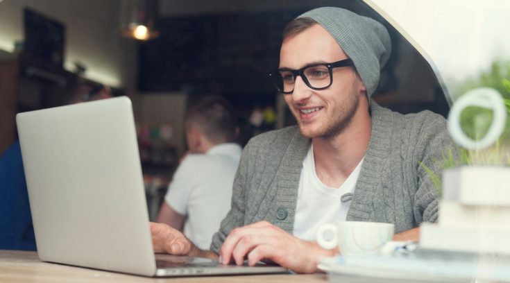 image of young man in glasses working on computer