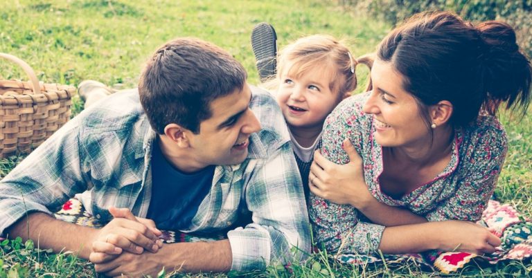 Middle America You Can Have Kids Without Going Broke - picture of parents with little girl in grass