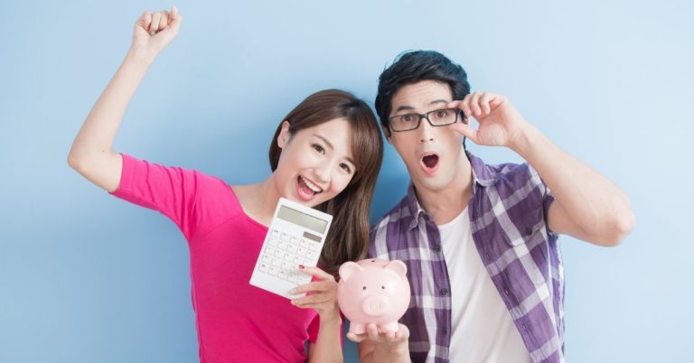 Personal Loan vs Balance Transfer Credit Card - picture of young couple with calculator and piggy bank celebrating