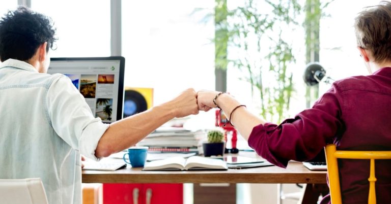 Self Financial Review - picture of two people at desk fist pumping