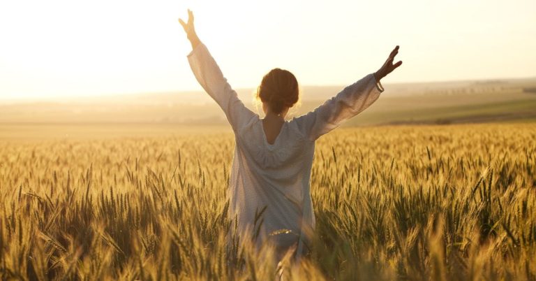 Simple Strategies to Destroy Debt Fast_picture of woman with arms raised in a wheat field