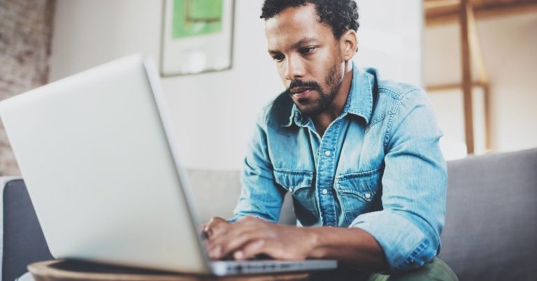 The Perils of Working From Home - Black man working at laptop at home