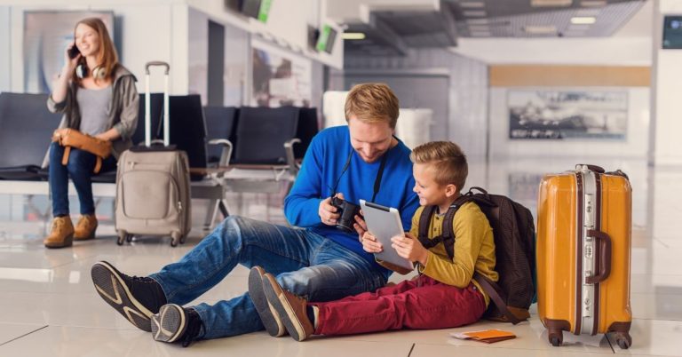 Tips for Saving Money at the Airport - picture of family in airport lounge playing games