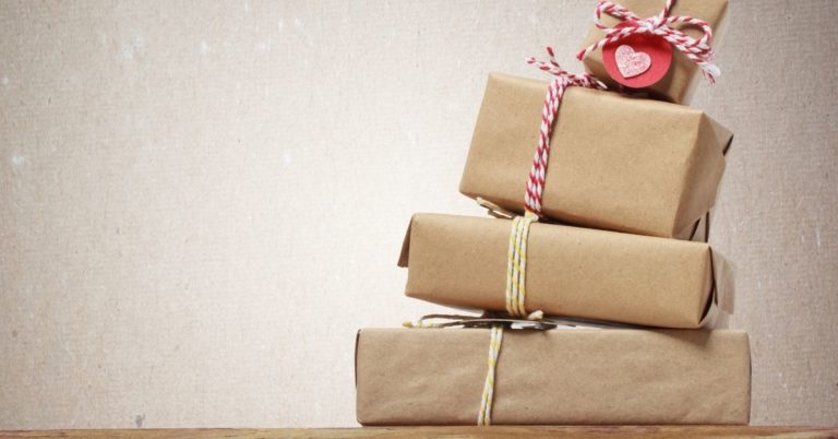 Tips Keep Holiday Spending in Check - picture of hand-wrapped tower of gifts falling over