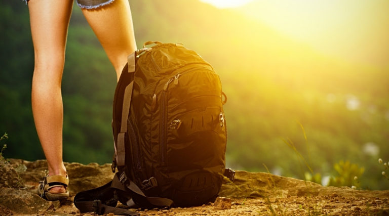 woman on mountain with travel backpack