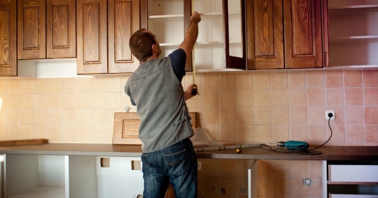 We Went $3,000 Over On Home Remodel - picture of man measuring kitchen cabinets