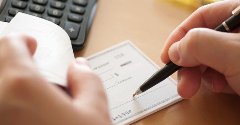 What is a checking account - upclose picture of hand writing a check