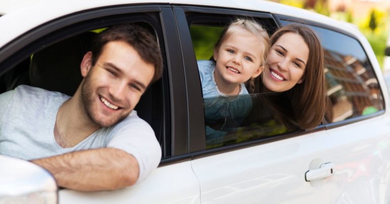 Why We're Becoming a One-Car Family - picture of family sticking heads out of white car